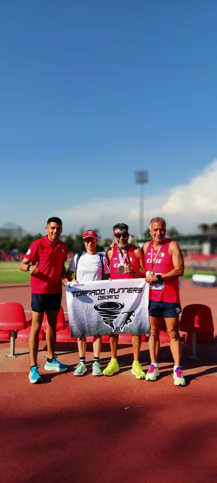 Atletas de Tornado Runners con medallas y bandera del club